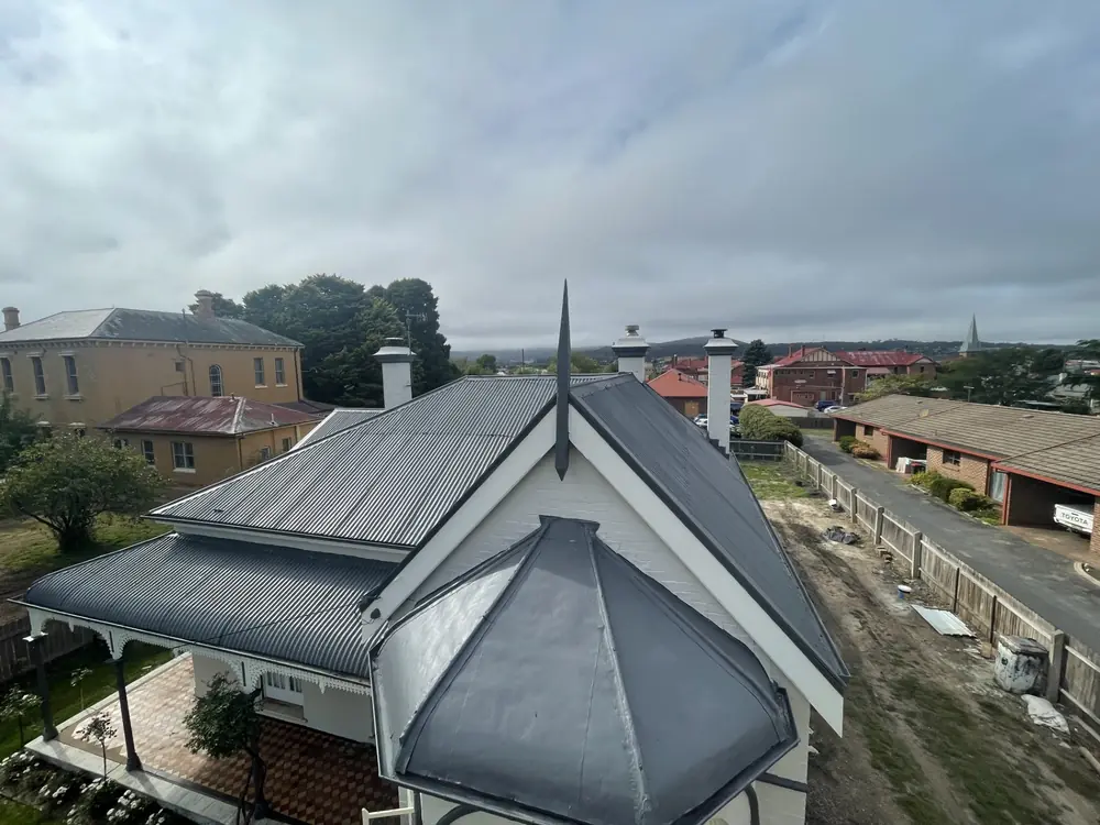 High view across a freshly coated corrugated roof and surrounding homes
